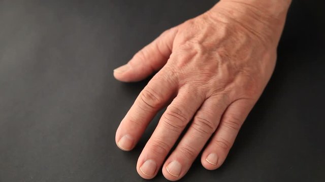 An older man has involuntary movement in his finger.
