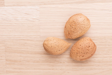 Almonds lying on wood table with copyspace. Food still life with raw nuts.