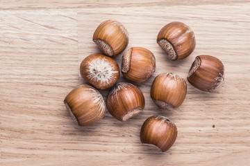 Hazelnuts lying on wood table. Food still life with raw nuts.
