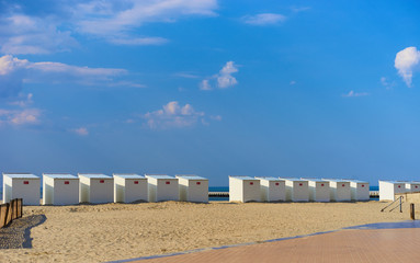 Fototapeta na wymiar Sandy beach of North Sea / Roofed beach chairs at beach of Nieuwpoort in Belgium