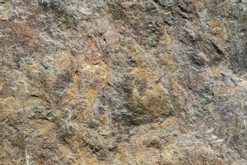 Stone background, rock wall backdrop with rough texture. Abstract, grungy and textured surface of stone material. Nature detail of rocks.