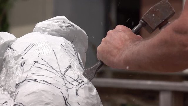 The artist creating sculpture of stone. Art studio. Slow Motion. Close-up shot. Artist  working with stone and sculpting statue