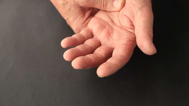 Senior man with index finger and thumb trembling