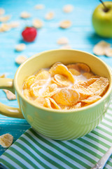 cornflakes with strawberry, apple on wooden table