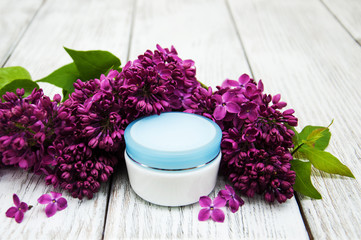 Fototapeta na wymiar moisturizing cream and lilac flowers