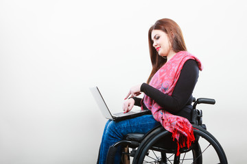 Disabled woman with laptop on wheelchair.