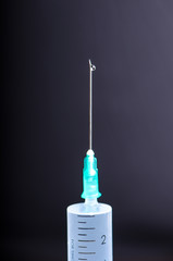 Medical injection on dark background. Medicine plastic vaccination equipment with needle. Health and care. Vaccination. Medicine background. Studio isolated. Phobia