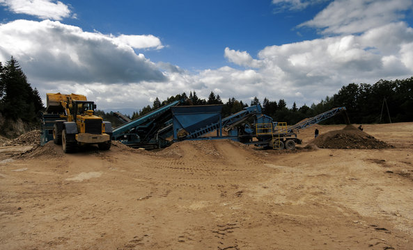 Digger And Conveyor Belt On Construction Site