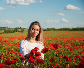 Obraz na płótnie Canvas young girl in the poppy field