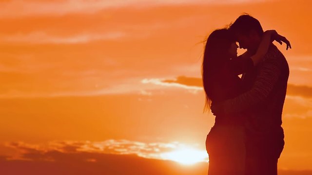 girl hugging a man at sunset slow motion video