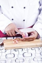 Chef peeling red onion with knife