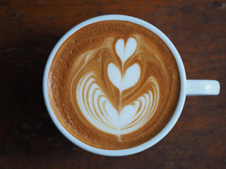 Coffee latte art with vintage color on wood table