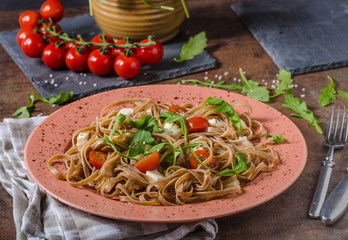 Spaghetti with mozzarella, cherry tomatoes and arugula