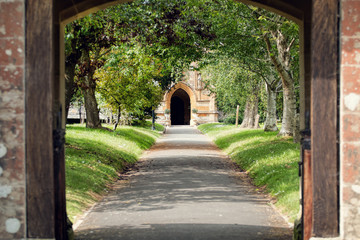 Fototapeta na wymiar Church Path. Peaceful tree lined pathway through churchyard.