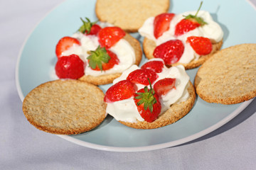 Oat buiscits with cream and fresh strawberries, close up