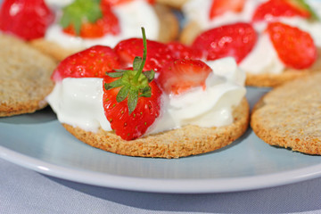 Oat buiscits with cream and fresh strawberries, close up
