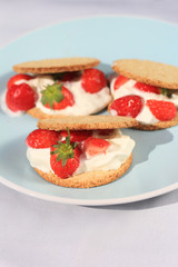 Oat buiscits with cream and fresh strawberries, close up