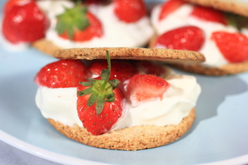 Oat buiscits with cream and fresh strawberries, close up