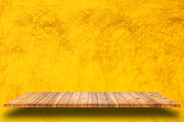 Empty wooden shelves and yellow cement wall background.