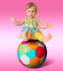 Beautiful baby girl balancing o a huge ball