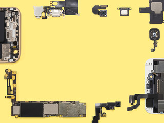 Flat lay (top view) of smart phone components isolate on yellow background with copy space