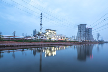 Fototapeta premium modern power station near river at twilight