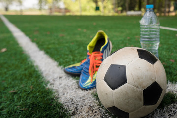 Football cleat and fresh water after the match on the field