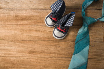 Fathers day composition of colorful tie laid and baby shoes on w