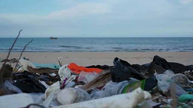 Waste like plastic bottles and bags or other garbage lying on polluted beach in Asia.