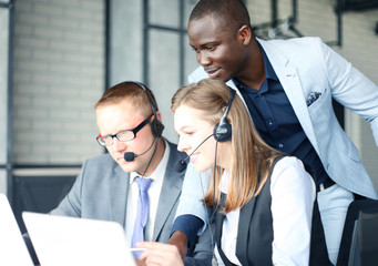 Phone operator working at call centre office helping hiss colleague