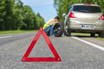 Male driver with spare wheel on the roadside