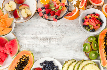 Preparing a healthy fruit salad on white wooden  background. © bit24