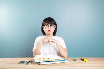 Portrait of clever  asian student with open book reading it