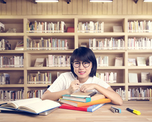 Portrait of clever  asian student with open book reading it