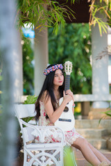 Fototapeta premium girl in a wreath of wild flowers with her guitar