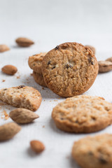 Cookies pile with chocolate chip and almond on light textile background. Delicious morning snacks for breakfast, brunch and lunch. Appetizing, healthy and fast food