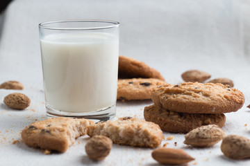 Cookies pile with chocolate chip and almond on light textile background. Delicious morning snacks for breakfast, brunch and lunch. Appetizing, healthy and fast food