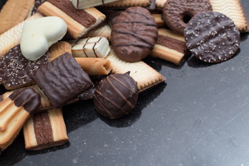 Cookies assorted on black background. Delicious morning snacks for breakfast, brunch and lunch. Appetizing, sweet and fast food.