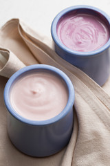 Yogurts assortment  in ceramic bowls on wooden ligth background. Natural and fruit  healthy, diet, gourmet dessert for granola breakfast. Sweet yogurts closeup.