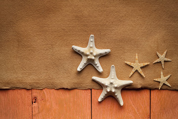 Fototapeta na wymiar Handmade paper sheet and starfish on wooden planks