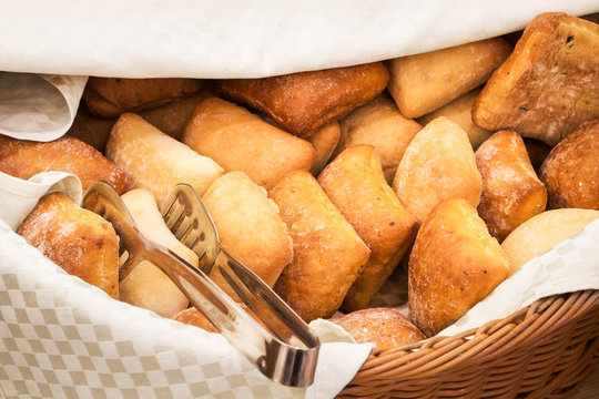 Basketful of ciabatta bread with tongs