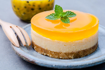 Passion fruit cheesecake with fresh mint leaves on dark backgrou