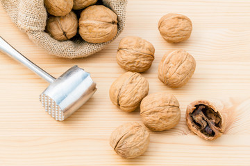 Walnuts kernels and whole walnuts on wooden background. Whole an