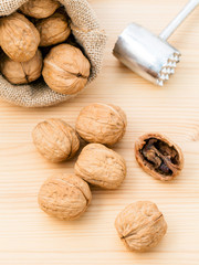 Walnuts kernels and whole walnuts on wooden background. Whole an