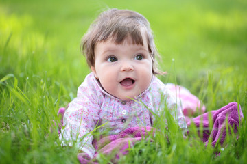 Cute baby girl on green grass