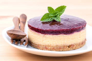 Blueberry cheesecake with fresh mint leaves on wooden background
