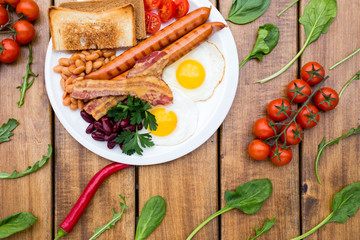 Traditional breakfast with bacon and fried eggs. top view