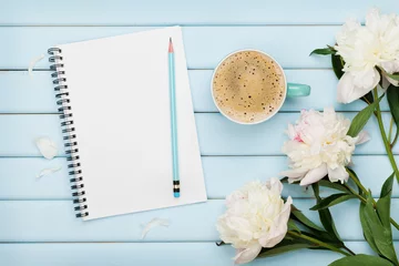 Rolgordijnen Morning coffee mug, empty notebook, pencil and white peony flowers on blue wooden table, cozy summer breakfast, top view, flat lay © juliasudnitskaya