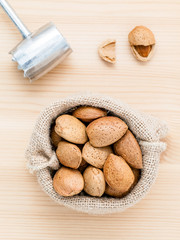 Almonds kernels and whole almonds on wooden background. Whole an