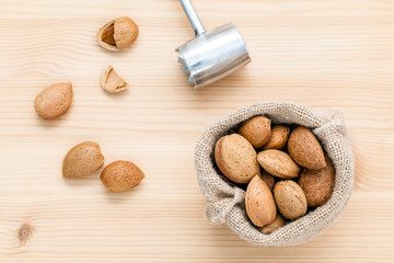 Almonds kernels and whole almonds on wooden background. Whole an